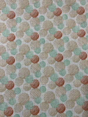 Linen fabric with a a retro abstract polka dot print fabric in mint, beige, and rust on an ivory background. The circles vary in size and are filled with fine diagonal stripe textures, creating a layered geometric look with a hand-printed feel.