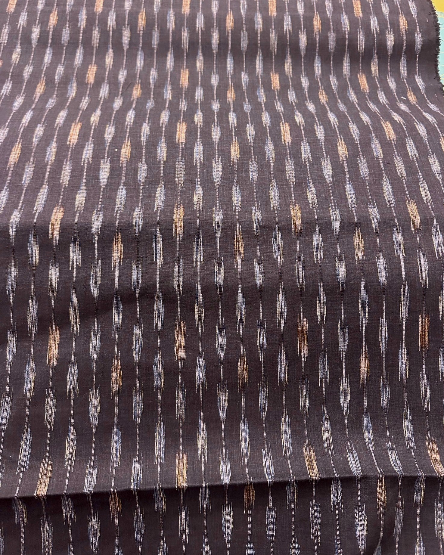 Two fabric swatches, one red with a subtle pattern and one black with a blue and beige pattern, side by side.