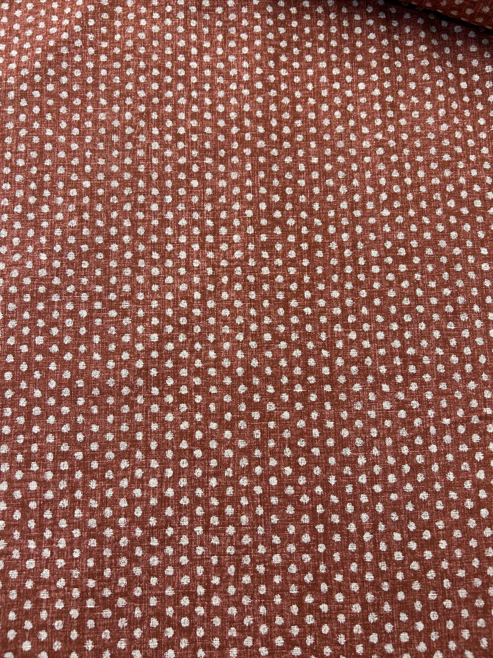 Close-up of red fabric with a subtle polka dot pattern