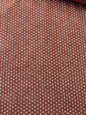 Close-up of red fabric with a subtle polka dot pattern