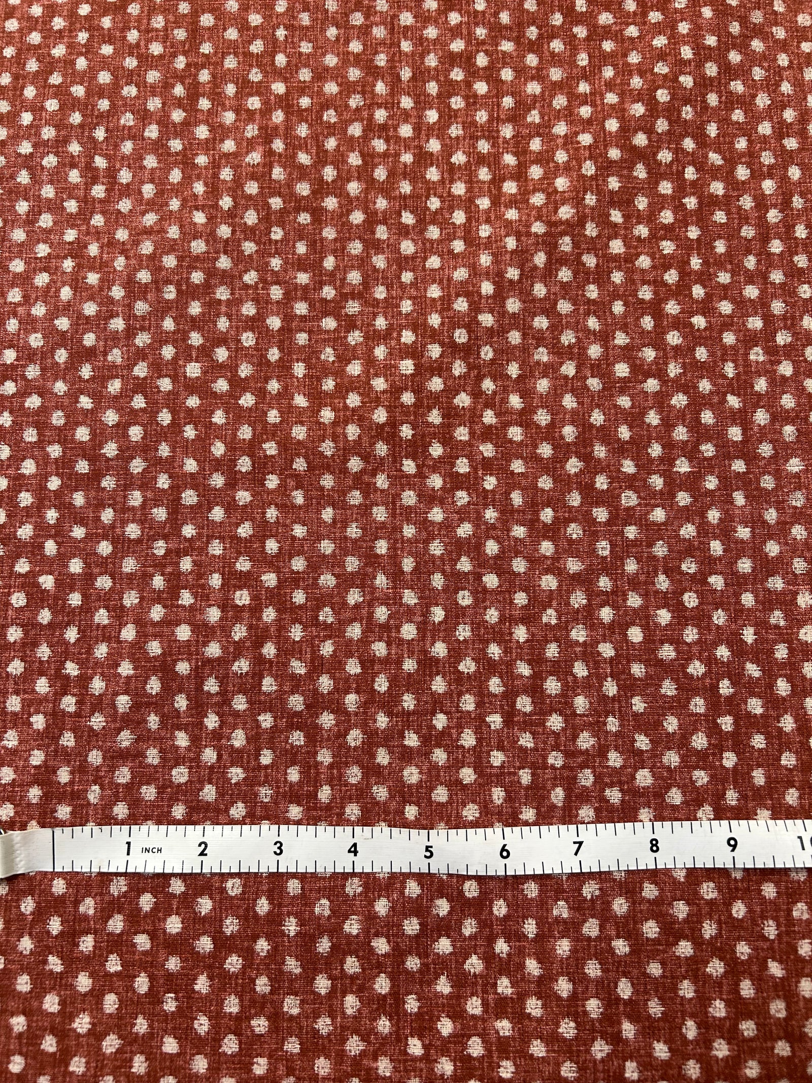 Close-up of red fabric with a subtle polka dot pattern