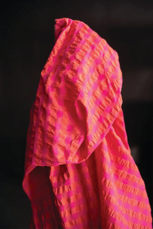 A summery bouncy cotton seersucker in a bright combination of fuchsia and orange.