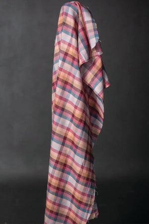 A cotton check fabric in berry tones on a dark grey background.