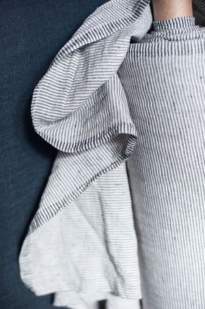 roll of fabric with navy blue and white skinny stripes on a navy blue background.
