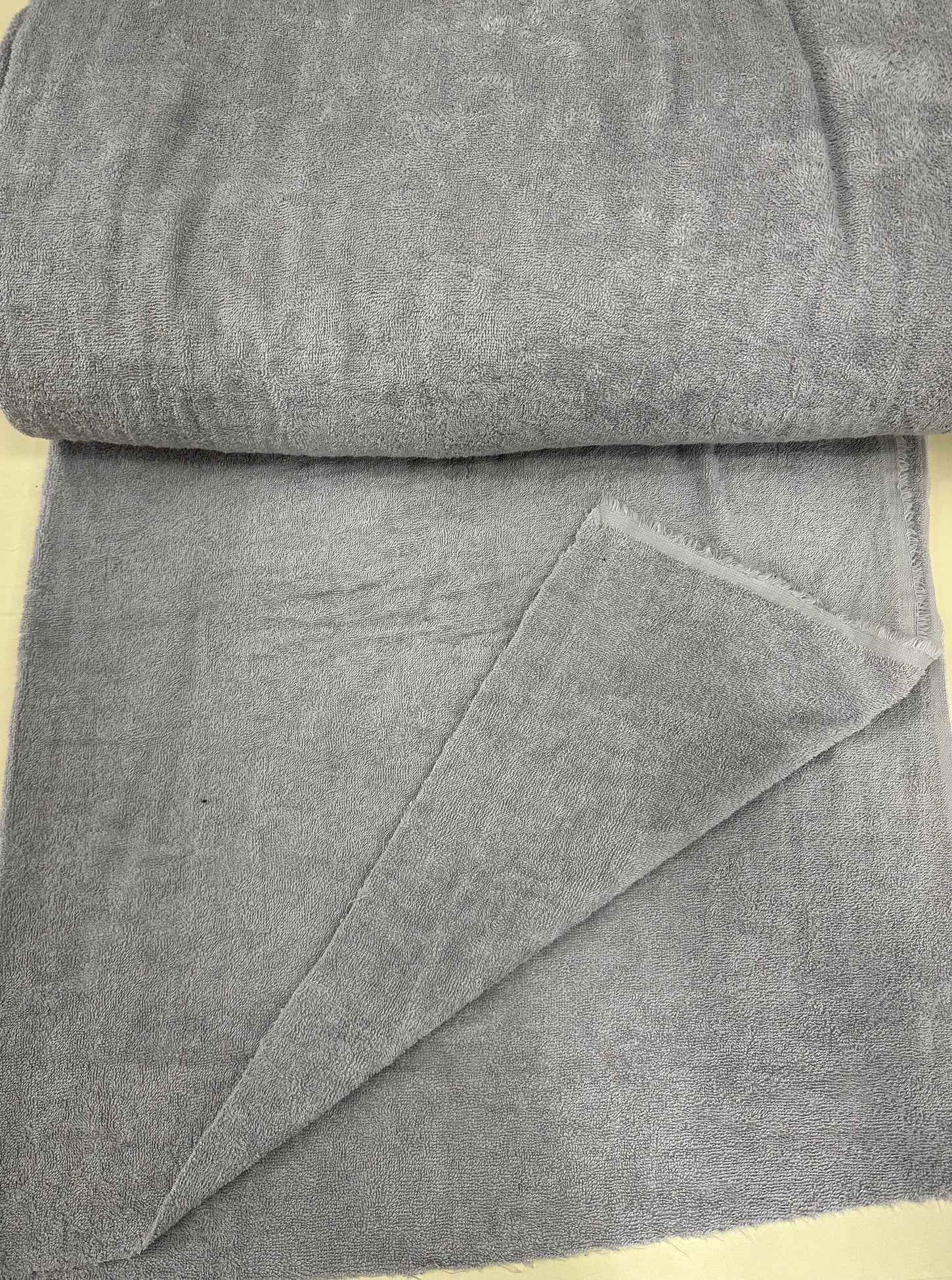 Roll of gray terryfabric on a beige surface