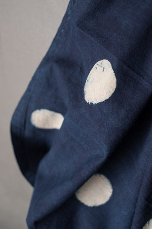 close up of Indian cotton fabric in dark Indigo with white block printed circles. 