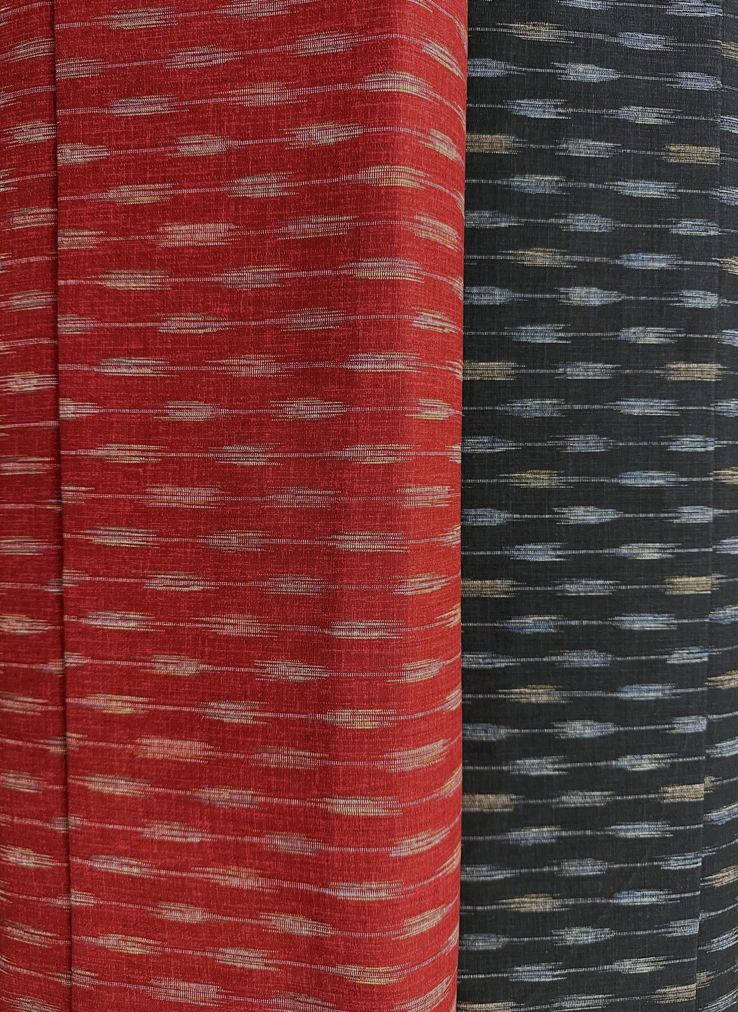Two fabric swatches, one red with a subtle pattern and one black with a blue and beige pattern, side by side.