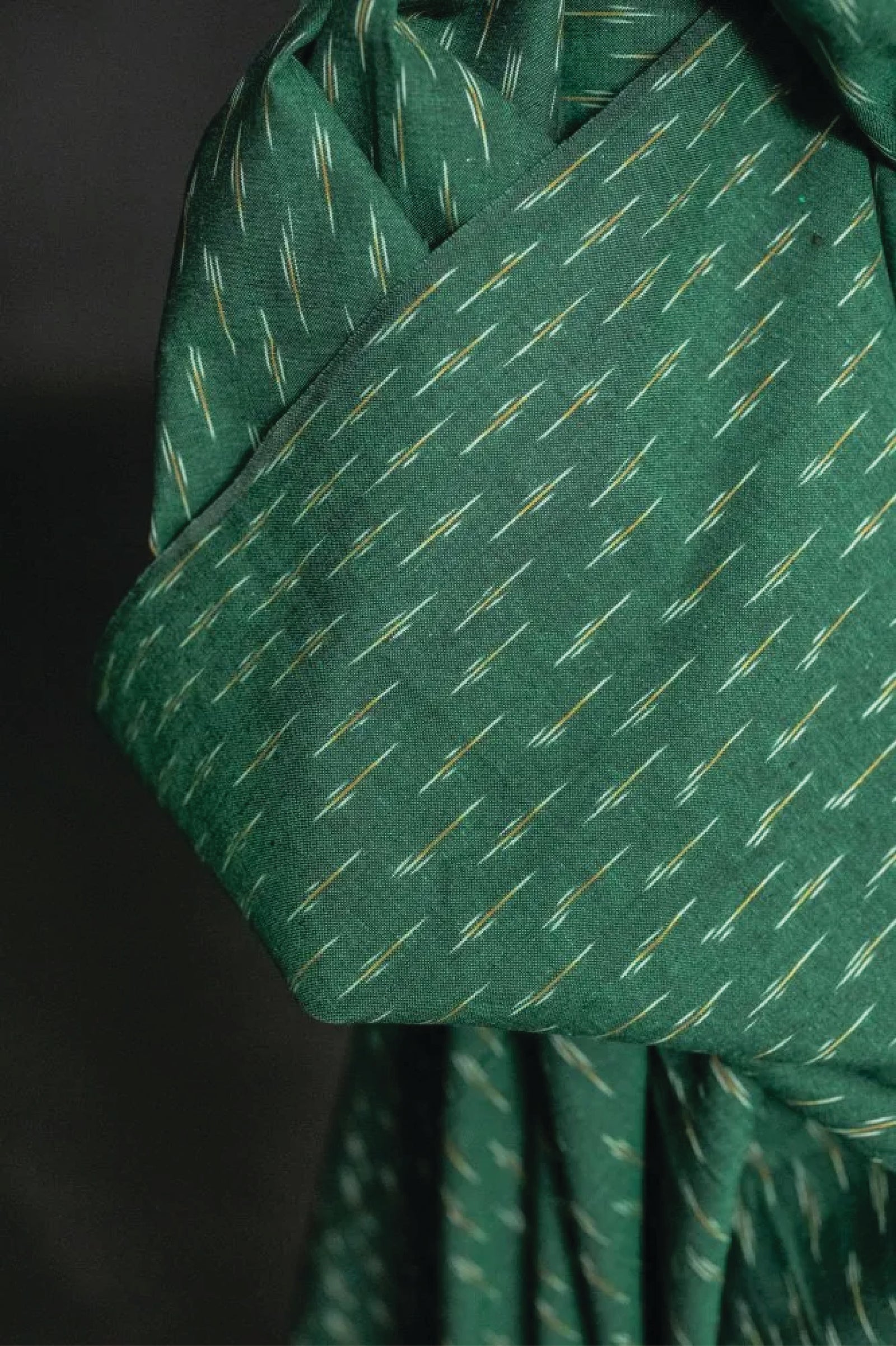A stunning chequered Ikat weave with ochre and white dashes on a background of dark emerald green.