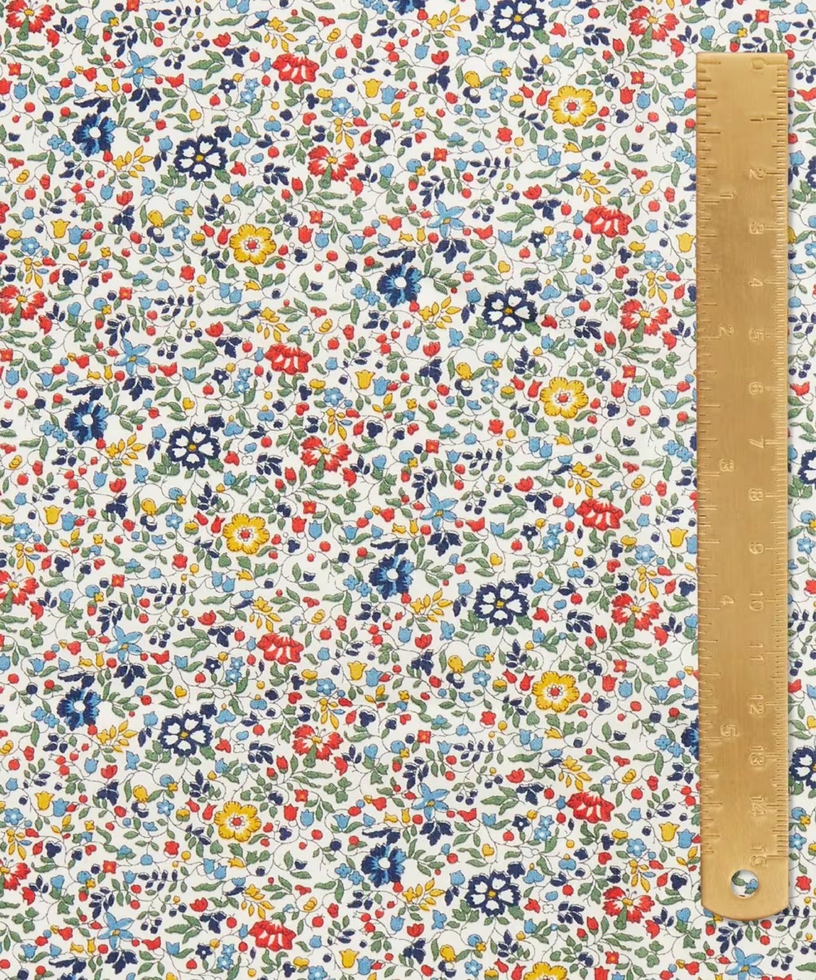 This draped vibrant fabric has a beautiful vintage ditsy floral print of blue, reds, greens, and yellows.