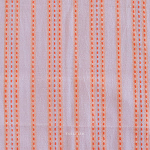 Lavender fabric with orange vertical stitched stripes .