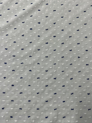 Italian cotton fil coupé fabric features a subtle jacquard-woven Swiss Dot pattern in white and navy on a white background.