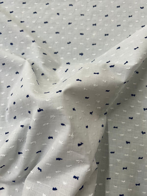 Italian cotton fil coupé fabric features a subtle jacquard-woven Swiss Dot pattern in white and navy on a white background.