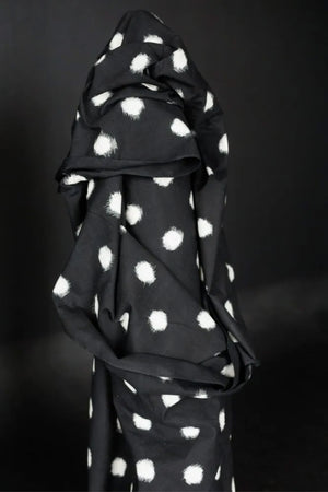 Bold monocrome Ikat with a black background and off white spot fabric on a dark grey background.