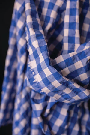 close up of a  summery bouncy cotton seersucker in a bright cobalt blue and a very light baby pink.