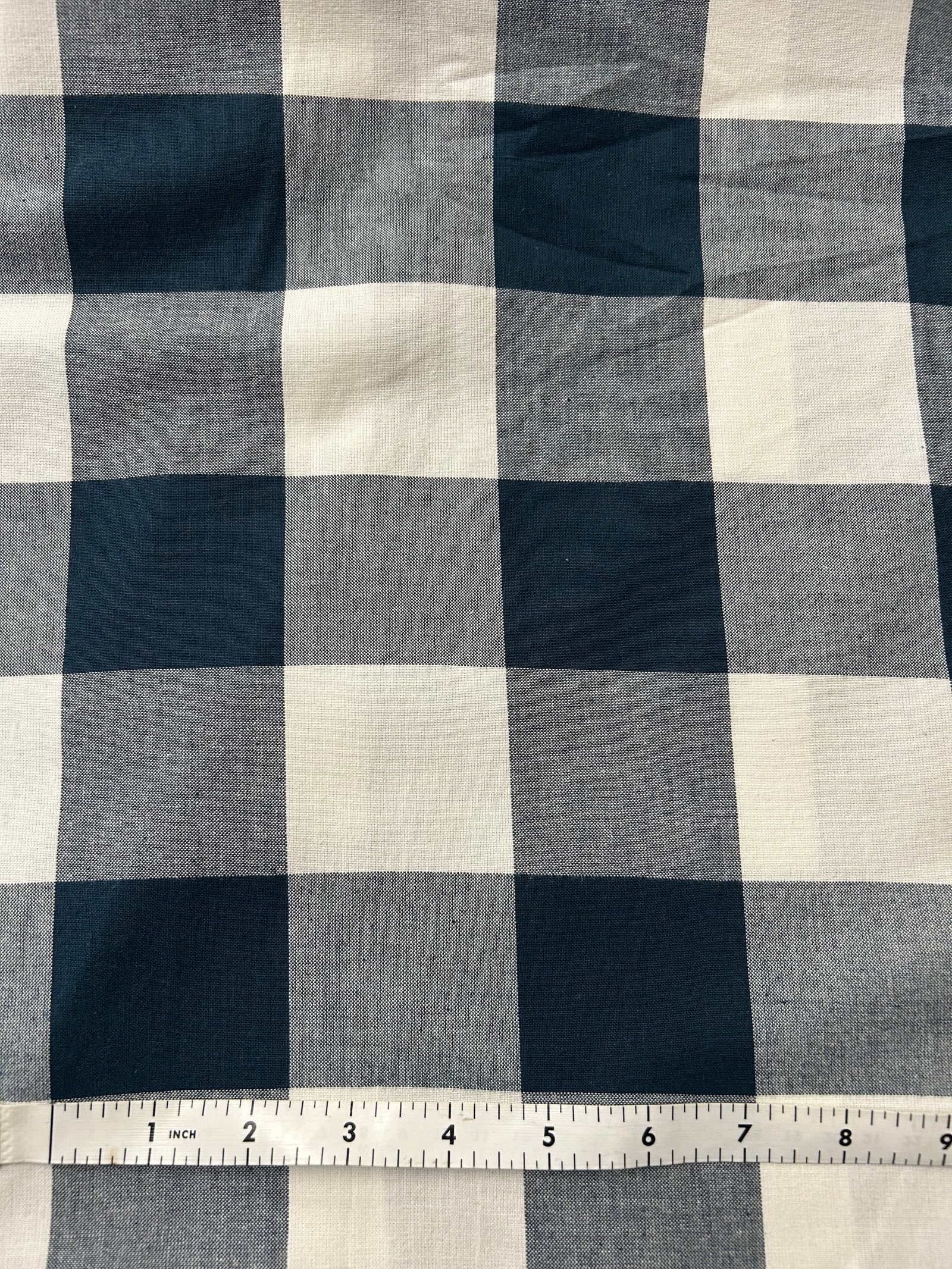 Navy and white checkered gingham fabric on a light background.