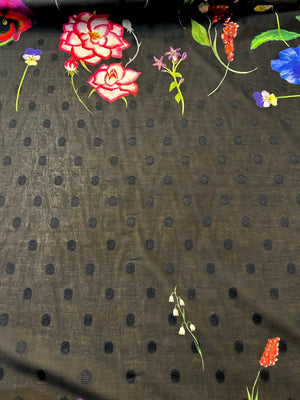 Floral pattern with pink roses and colorful flowers on a black polka dot background