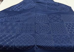 Sashiko fabric with white geometric patterns on a blue background