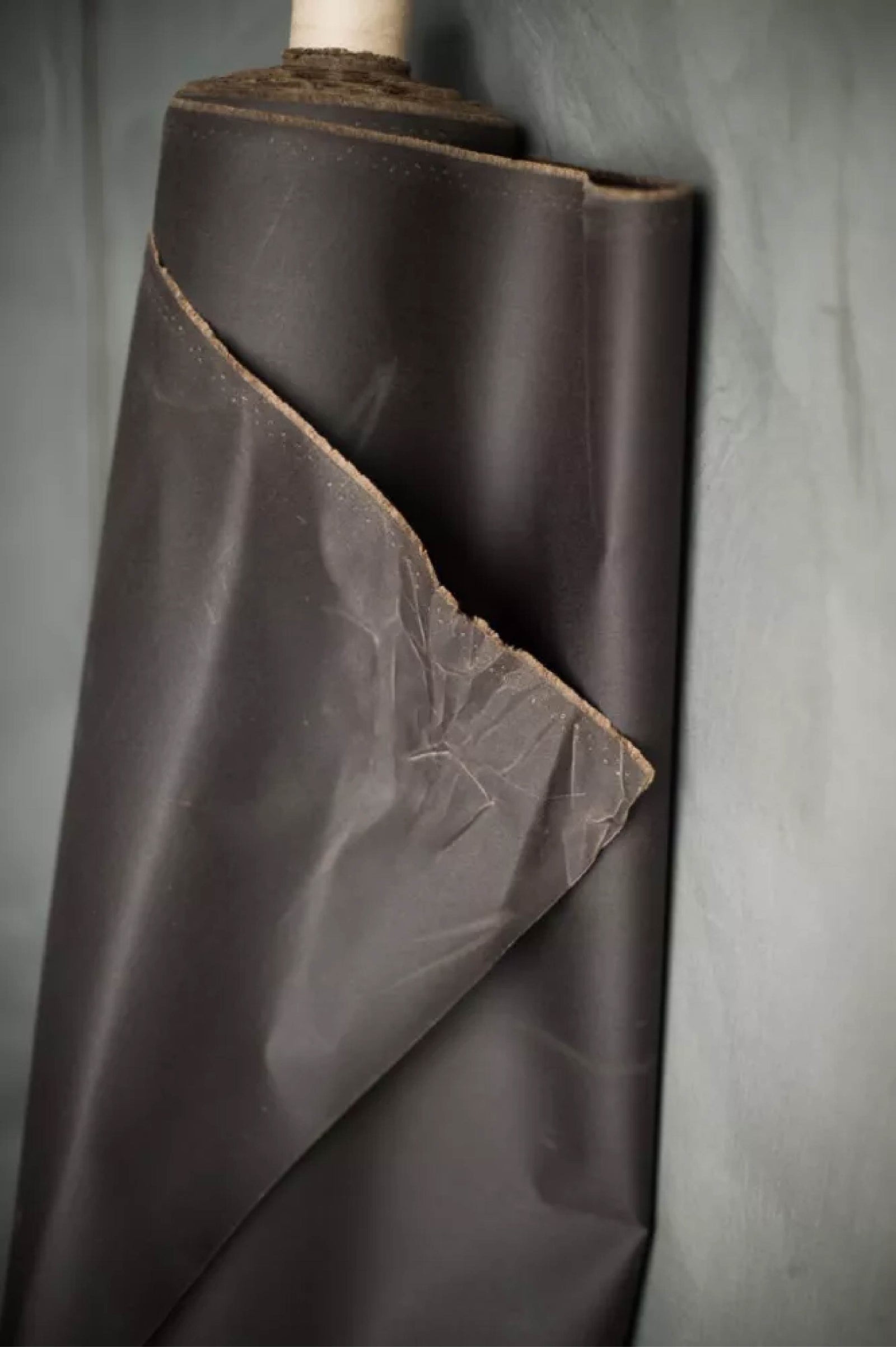 Brown oilskin fabric roll on a gray background