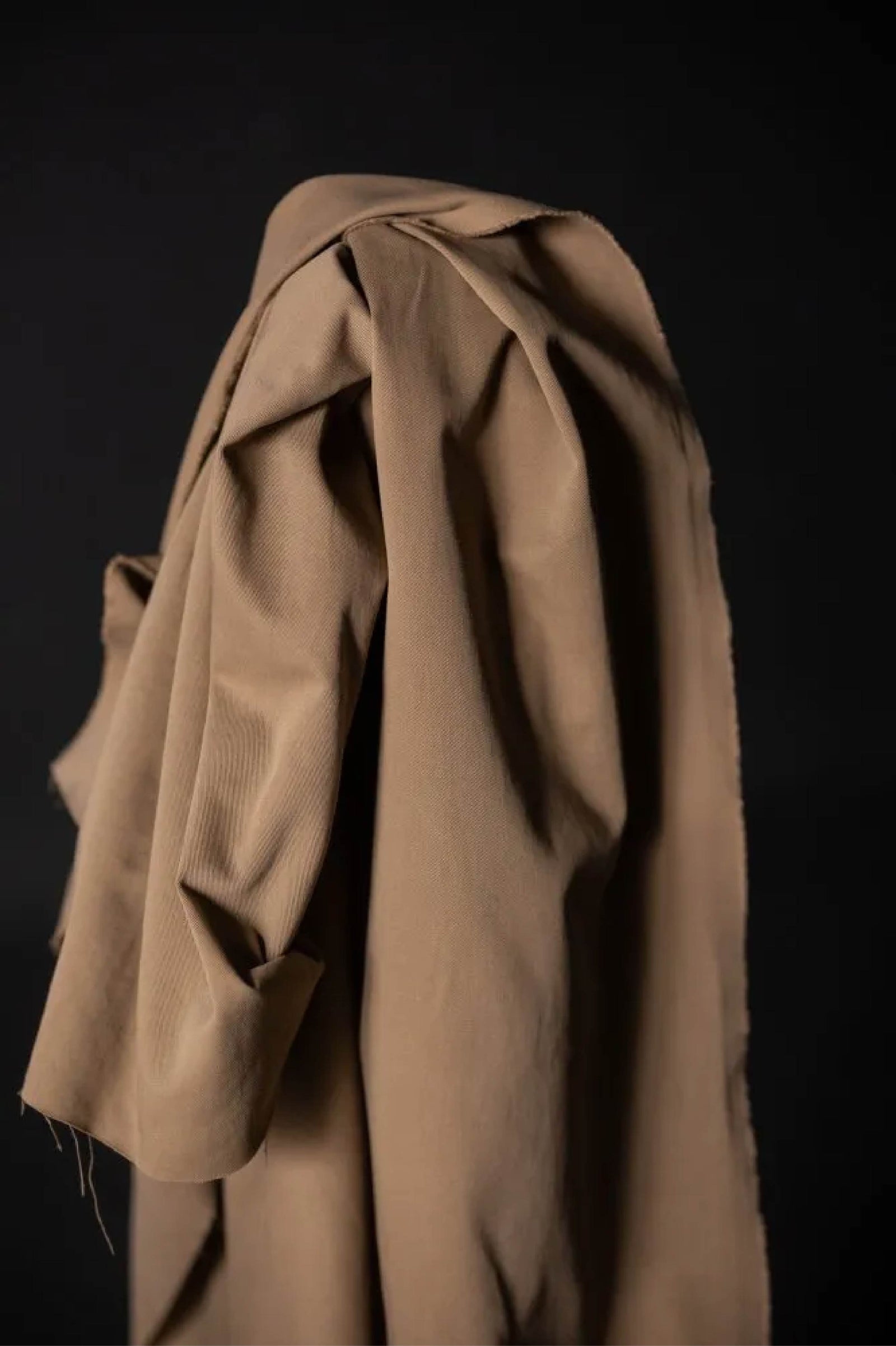 tan fabric roll against a black wall