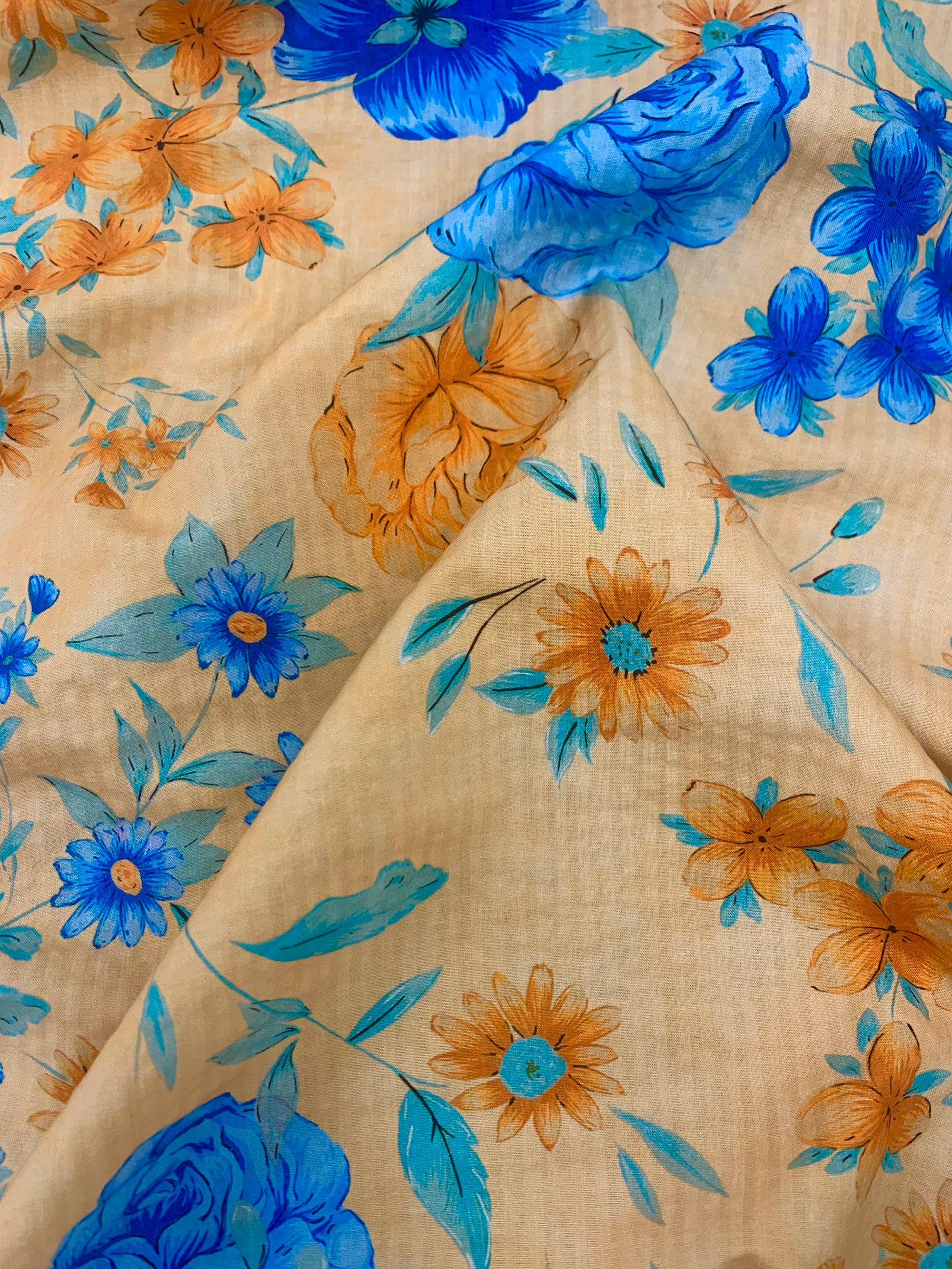 flat cotton seersucker in a pale orange with orange and royal blue floral print