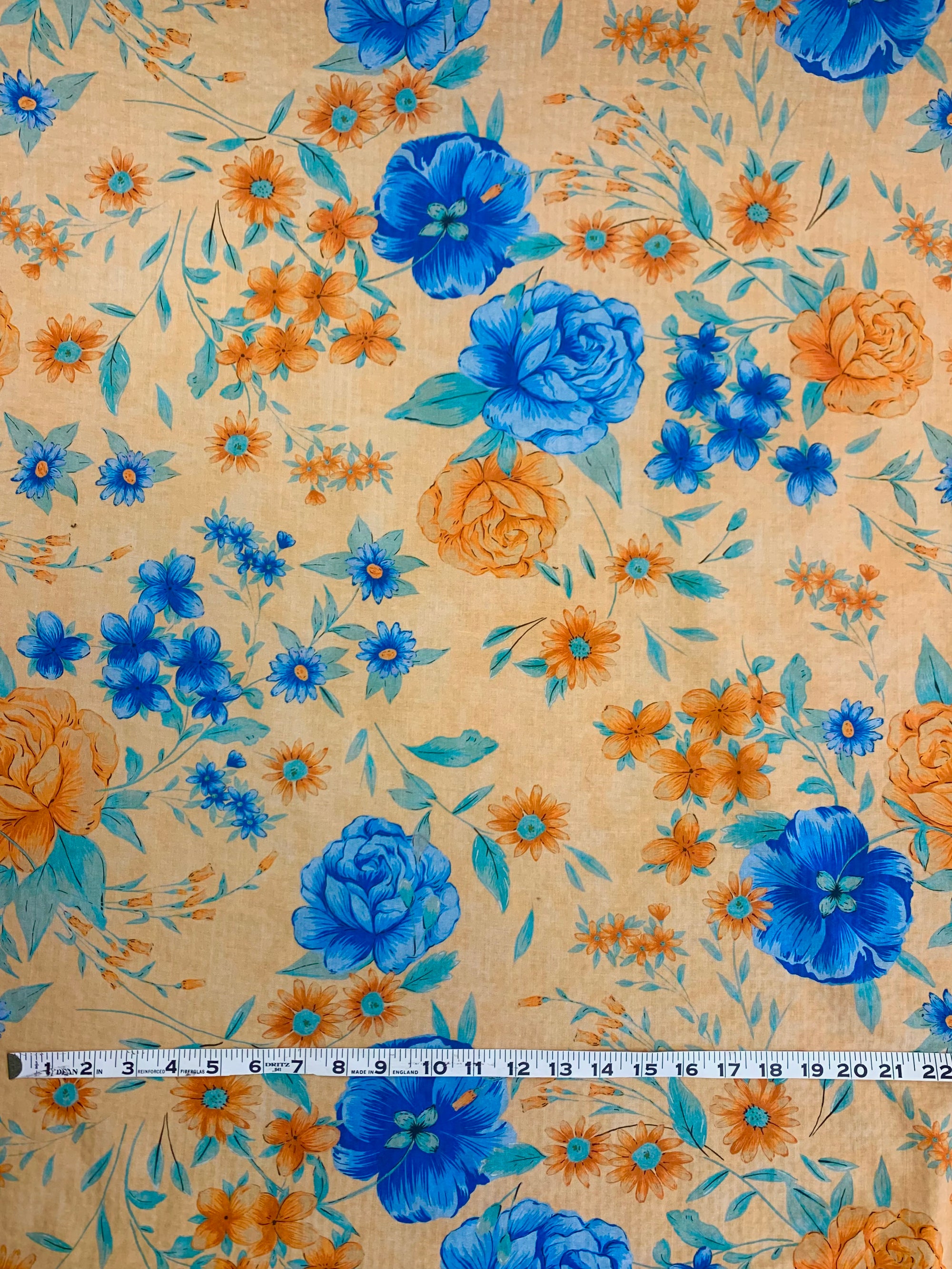 flat cotton seersucker in a pale orange with orange and royal blue floral print