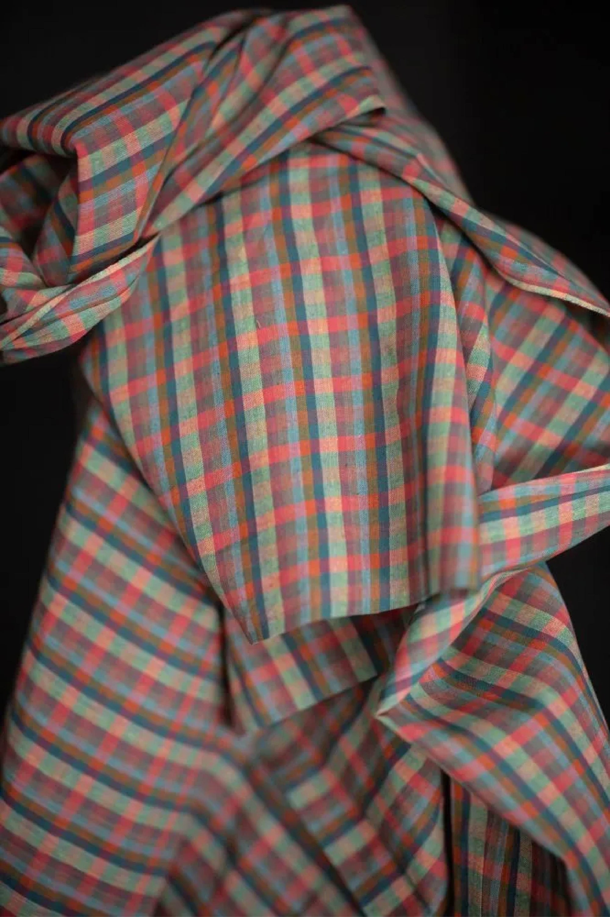 Plaid fabric with red and green pattern on a dark background