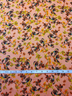 Leafy pattern with green, orange, and brown leaves on a peach background with a ruler at the bottom for scale.
