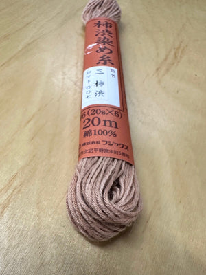 Ball of thread with a label on a wooden surface