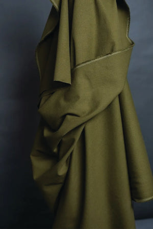 Green fabric draped over a dark background.