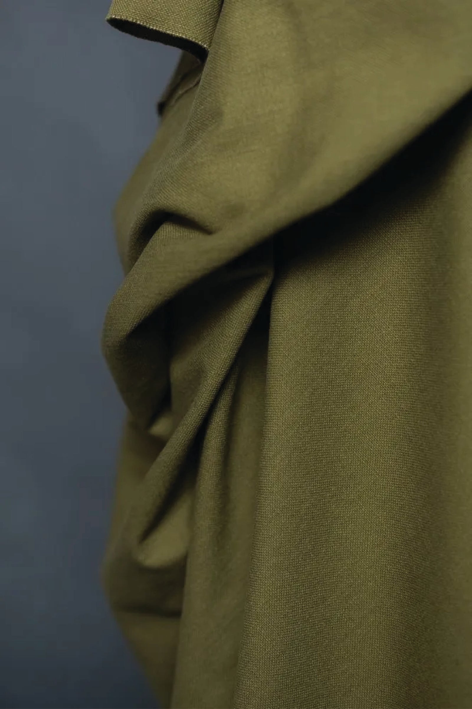 Close-up of green fabric against a grey background.