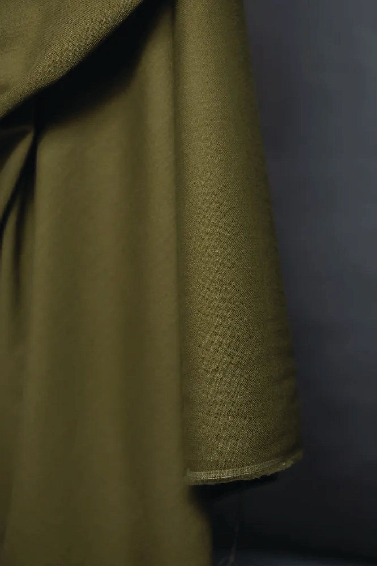Close-up of green fabric against a grey background.
