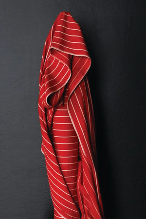 A wide red and think white striped fabric on a dark grey background.
