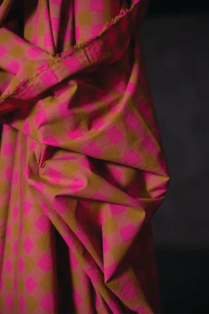 Cotton check fabric of fuchsia, mauve and ochre.