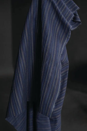 linen/cotton blend in a dark blue fabric with green, blue and tan stitch detail running parallel to the selvedge
