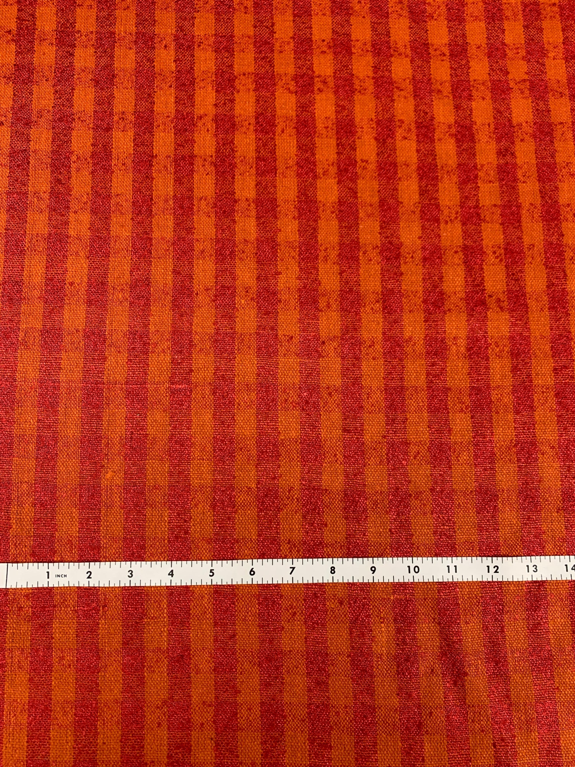 raw silk in a orange and red check with a measuring tape on the bottom. Checks are half and inch wide.