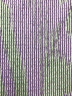 A cotton seersucker fabric in a striped Lilac and White vertically 