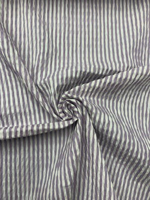 A spiraled  cotton seersucker fabric in a striped Lilac and White vertically