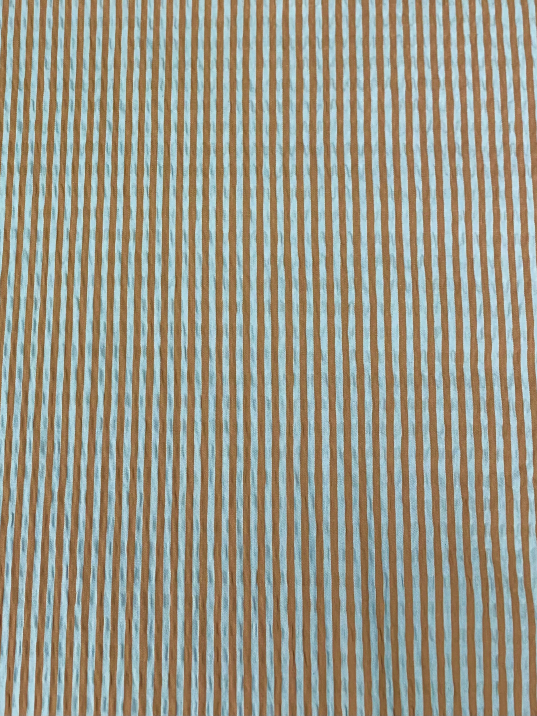 Close up of cotton seersucker fabric  in a striped Orange and White vertically