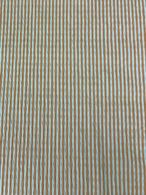 Close up of cotton seersucker fabric  in a striped Orange and White vertically