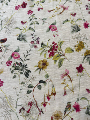 Floral patterned fabric with pink, yellow, and green flowers on a light background