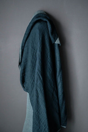 wool/linen blend roll of fabric in teal wit a dark grey background
