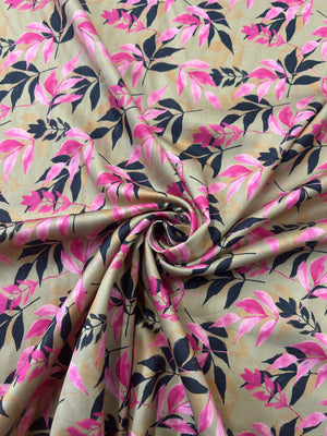 Fabric with pink and a black silhouette leaf pattern on tan background. In a swirl.