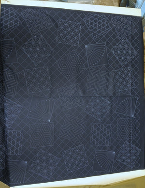 Dark fabric with white geometric patterns on a wooden surface