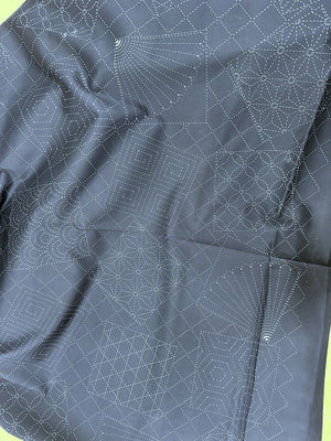 Dark fabric with white geometric patterns on a green background