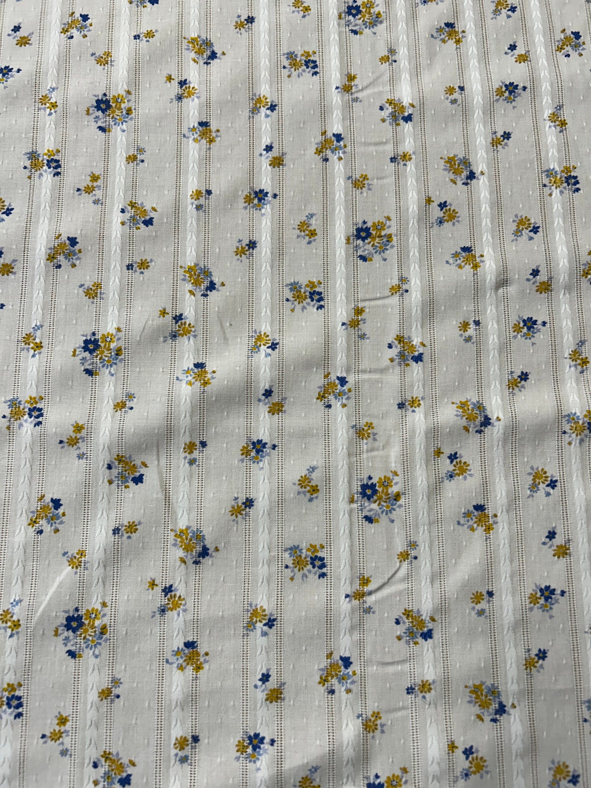 cotton fabric with a vintage blue and mustard floral print with embroidered vertical stripes.
