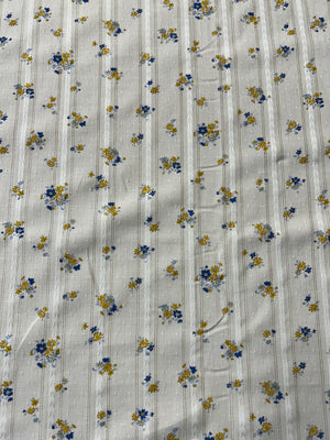 cotton fabric with a vintage blue and mustard floral print with embroidered vertical stripes.
