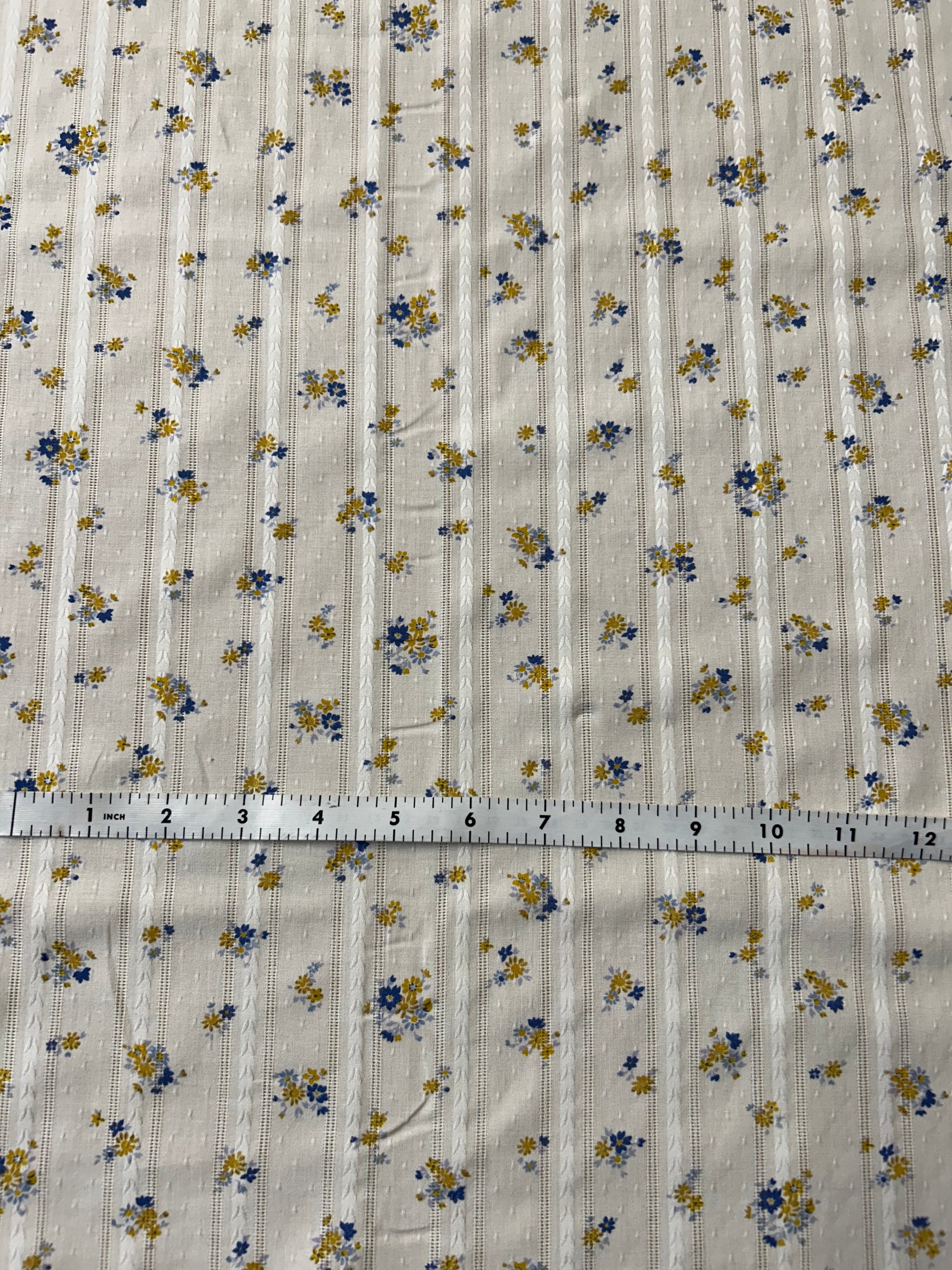 cotton fabric with a vintage blue and mustard floral print with embroidered vertical stripes.