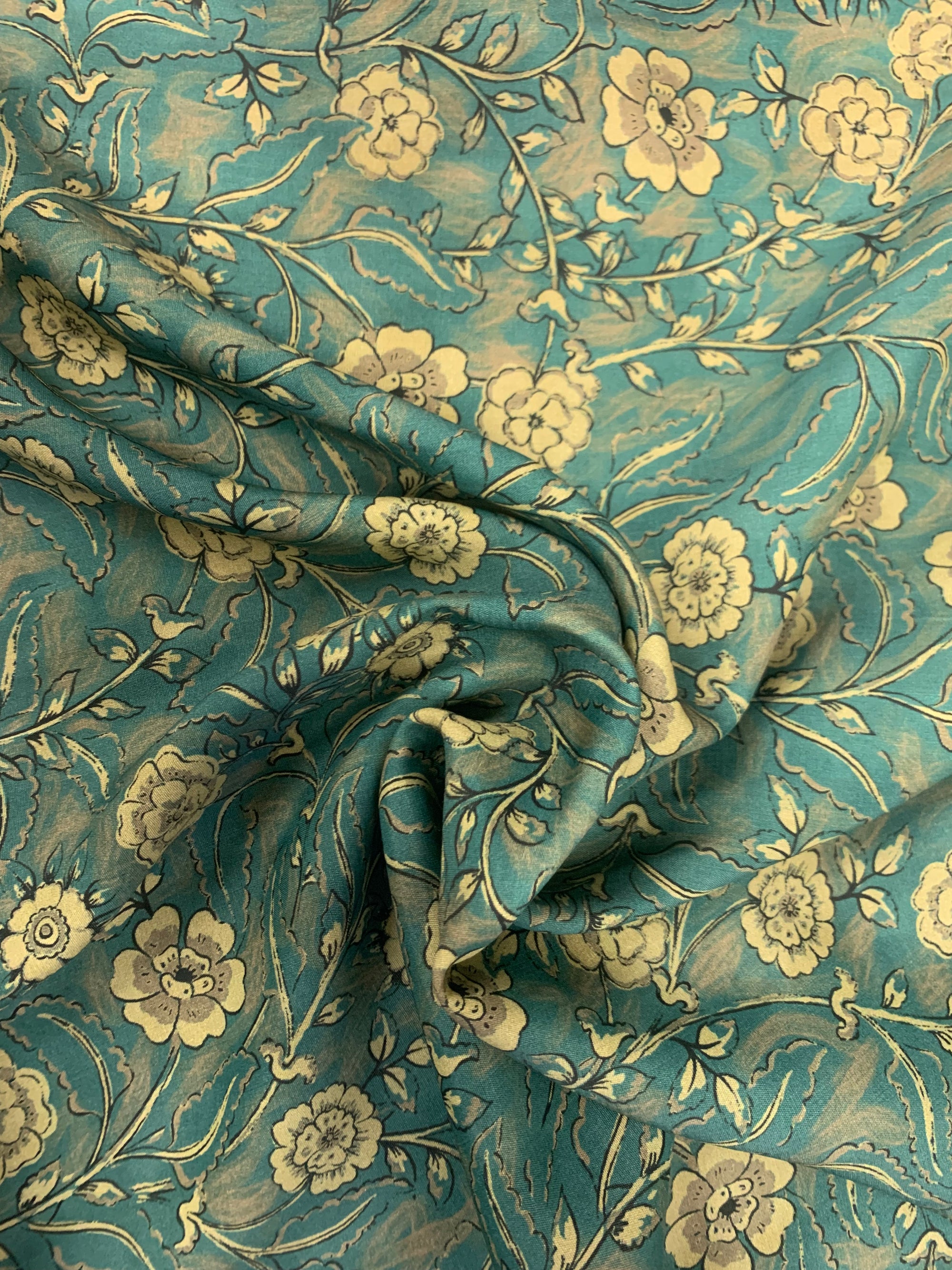 Viscose Challis Fabric is a Teal/Taupe floral print in a spiral.