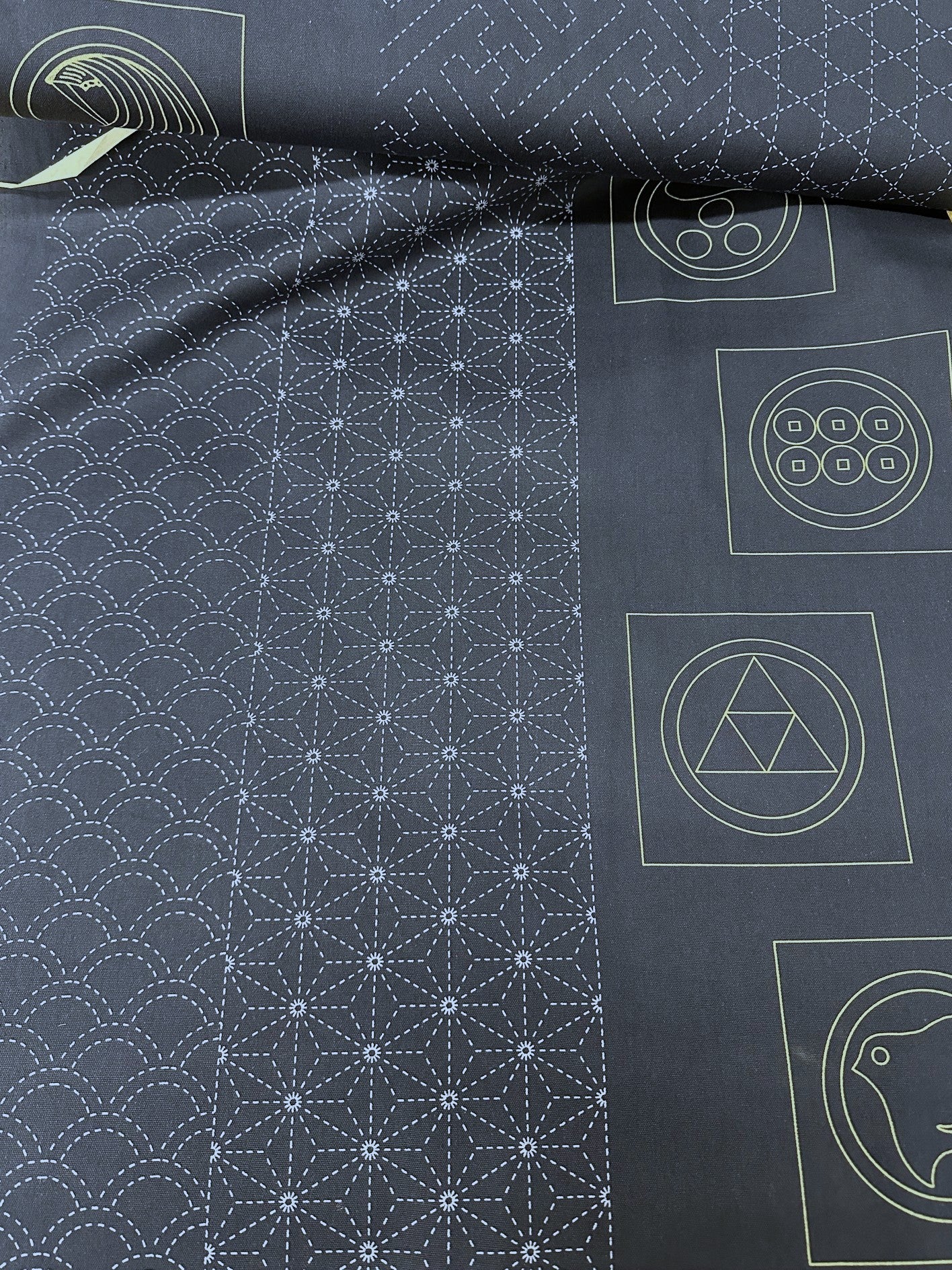 Roll of dark fabric with white sashiko patterns