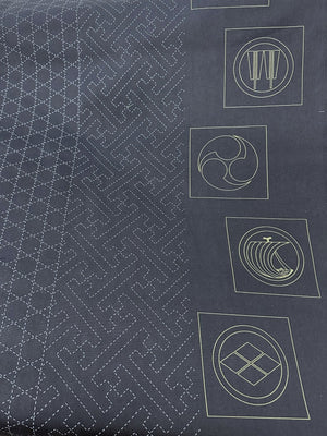 Dark fabric with white geometric sashiko patterns and symbols